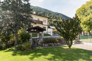 ein Gebäude mit einem Tor in einem Hof mit Bäumen in der Unterkunft Villa Marmarole a Calalzo in Calalzo