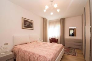 Schlafzimmer mit einem Bett und einem Kronleuchter in der Unterkunft Villa Marmarole a Calalzo in Calalzo
