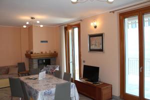 a living room with a dining room table and a television at Appartamento vista Lago - Mary in Lezzeno