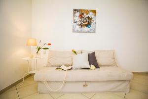 a couch in a living room with a painting on the wall at InnPisaRentals2 - Airstation Central Flat in Pisa +12 photos