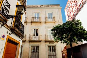 un alto edificio con balconi e un albero di Casa Patio del Siglo XIX a Siviglia