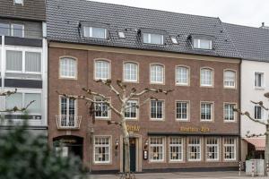Un edificio de ladrillo con un árbol delante. en Hotel Werk II, en Bocholt
