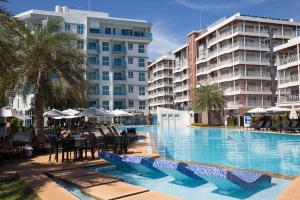 a swimming pool with tables and chairs and buildings at Grandbeach Condo Sea view by malai in Mae Pim