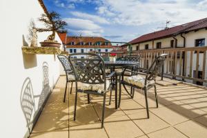 a patio with a table and chairs on a balcony at Hotel Bonsai in Mikulov