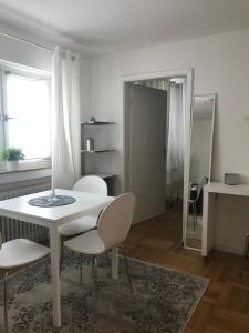 una sala da pranzo bianca con tavolo e sedie di Small Home a Freudenstadt