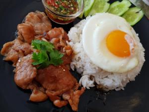 a plate of food with rice and an egg on it at The Chan - Sri Ayutthaya Road in Bangkok
