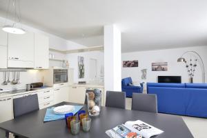 a kitchen and dining room with a black table and blue chairs at Villa Albachiara, Private Luxury villa with private pool and lake view in Gardone Riviera