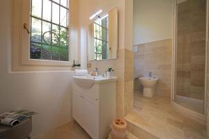 a bathroom with a sink and a toilet and a window at Villa FiordiSole in Salò +40 photos