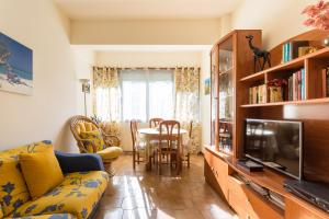 a living room with a couch and a tv at Casa da Praia in Costa da Caparica