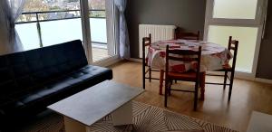 a living room with a table and chairs and a couch at t2 lumineux avec balcon in Saint Malo