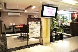 een tv aan de muur in een lobby met een restaurant bij The Key Bangkok Hotel in Bangkok