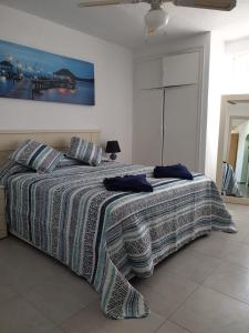 sypialnia z łóżkiem z kołdrą w paski w obiekcie Apartamentos ANNA vista Mar w mieście Benidorm