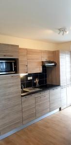 a kitchen with wooden cabinets and a counter top at t2 lumineux avec balcon in Saint Malo
