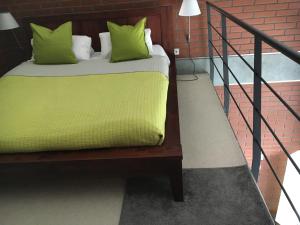a bed with green pillows on top of a staircase at Spa102 in Pobierowo