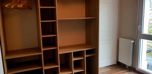 a closet with wooden shelves and a window at t2 lumineux avec balcon in Saint Malo +5 photos