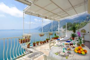 Una mesa en un balcón con vista al mar. en La Sorgente del Sole, en Positano