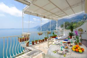 a table on a balcony with a view of the ocean at La Sorgente del Sole in Positano