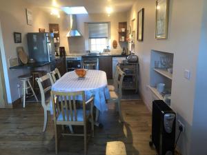 una cocina con una mesa con un gato sentado en ella en Luffness Castle Cottage, en Aberlady