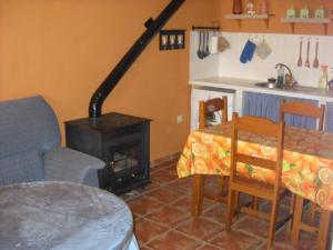 een keuken met een fornuis en een tafel en stoelen bij Casa Rural El Balcón de Cazorla in Tiscar