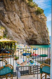 uma mesa e cadeiras junto a uma praia em Hotel Alfonso A Mare em Praiano