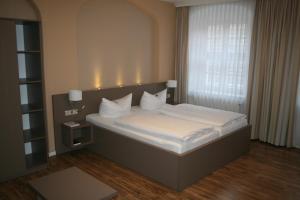 A bed or beds in a room at Hotel Am Obermarkt