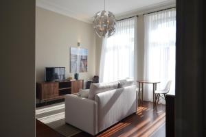 ein Wohnzimmer mit einem weißen Sofa und einem TV in der Unterkunft YOUROPO - Market in Porto