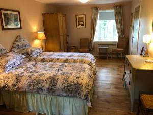 a bedroom with a bed and a desk and a window at Luffness Castle Cottage in Aberlady