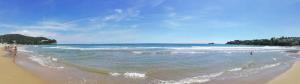 a beach with people standing in the water at Brezza di mare Gaeta b&b in Gaeta