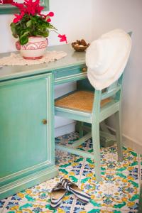 a blue desk with a chair and a plant at Hotel Alfonso A Mare in Praiano