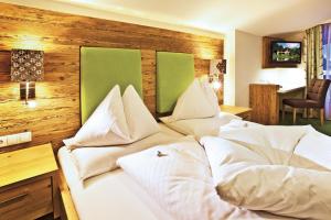 Łóżko lub łóżka w pokoju w obiekcie Landhotel Alpenhof Filzmoos