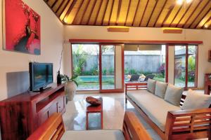 - un salon avec un canapé et une télévision dans l'établissement Villa Aprikot Ubud, à Ubud