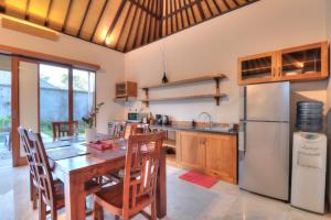 Il comprend une cuisine équipée d'une table en bois et d'un réfrigérateur. dans l'établissement Villa Aprikot Ubud, à Ubud