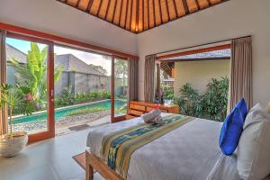 sypialnia z łóżkiem i dużym oknem w obiekcie Villa Aprikot Ubud w mieście Ubud