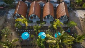 einen Luftblick auf ein Resort mit Palmen und blauen Sonnenschirmen in der Unterkunft The Rurus Bungalow in Nusa Penida