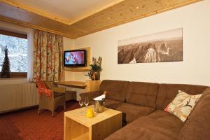 salon z kanapą i stołem w obiekcie Landhotel Alpenhof Filzmoos w mieście Filzmoos