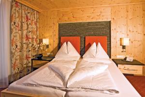 Łóżko lub łóżka w pokoju w obiekcie Landhotel Alpenhof Filzmoos