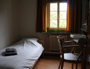 a bedroom with a bed and a desk at Het Klooster Breda in Breda
