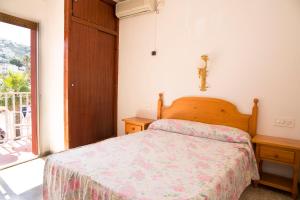 un dormitorio con una cama y una ventana en Hostal Susi, en Peñíscola