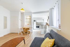 ein Wohnzimmer mit einem Sofa und einem Tisch in der Unterkunft Maison de ville pour 4 personnes in Marseille