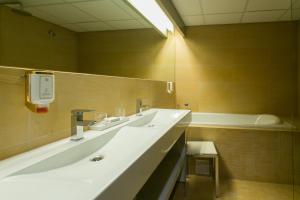a bathroom with two sinks and a mirror at Arensburg Boutique Hotel & Spa in Kuressaare