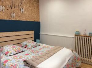 ein Bett mit einer Decke und Kissen in einem Schlafzimmer in der Unterkunft Kosy Suite in Saint-Aubin-du-Cormier