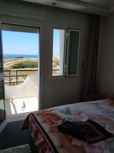 a bedroom with a bed and a window with a view at Achakar Hills , Piscine , Vue & Accès à la mer in Tangier