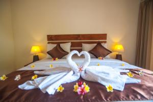 two swans making a heart shape on a bed at The Penida Bungalow in Nusa Penida