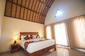a bedroom with a bed and a large window at The Rurus Bungalow in Nusa Penida