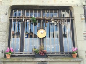 a window of a building with a hat and flowers at Kosy Suite in Saint-Aubin-du-Cormier