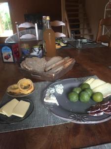 a table with a plate of cheese and other foods at Le Chat Blanc Gîte in Versols-et-Lapeyre