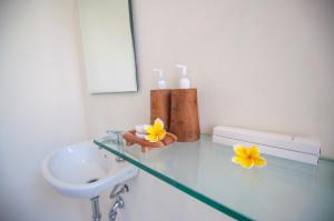 a bathroom with a sink and a glass counter at The Penida Bungalow in Nusa Penida +32 photos