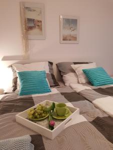 a tray with a plate of fruit on a bed at Baltic Sunset in Pobierowo