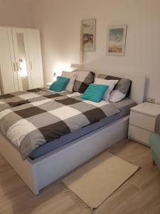 um quarto com uma cama grande e almofadas azuis e brancas em Baltic Sunset em Pobierowo