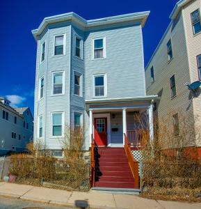 a blue house with a red door on a street at Boston Homestel in Boston